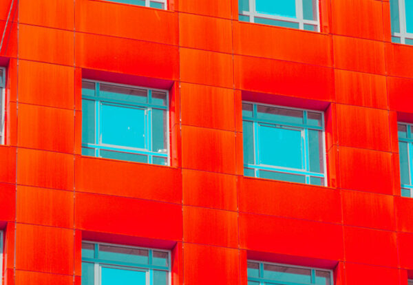 abstract facade of a modern building. Red square windows with blue glass